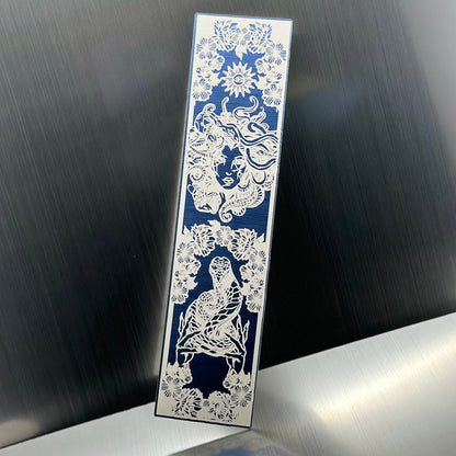 A blue metallic acrylic bookmark with Medusa's head at the top and a snake being held at the bottom