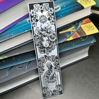 A silver metallic acrylic bookmark with Medusa's head at the top and a snake being held at the bottom