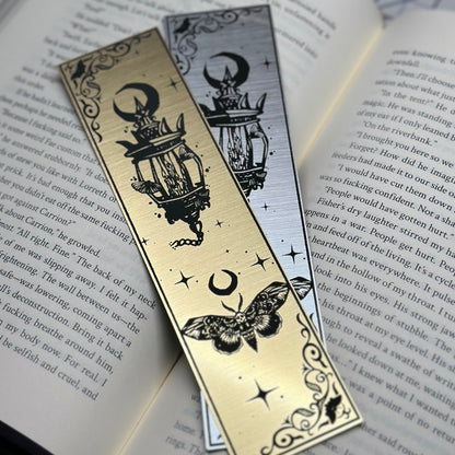 A lantern with a trio of moths on metallic acrylic bookmarks.