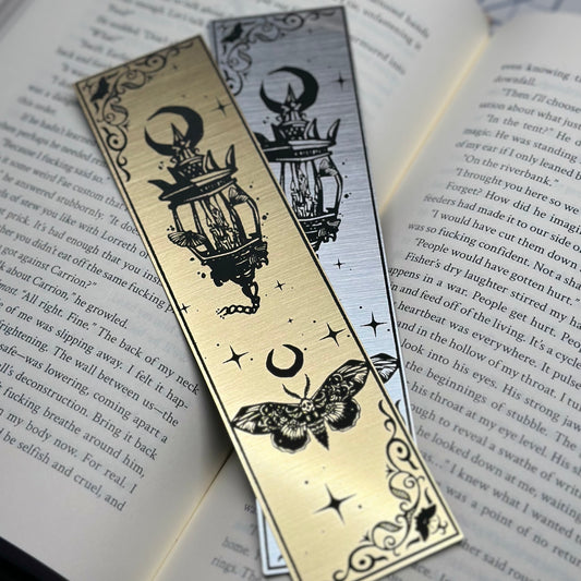 A lantern with a trio of moths on metallic acrylic bookmarks.