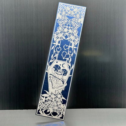 A blue metallic acrylic bookmark with skeletons embracing