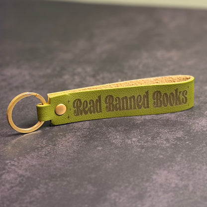 A green faux-leather keychain with 'Read Banned Books' etched into it.
