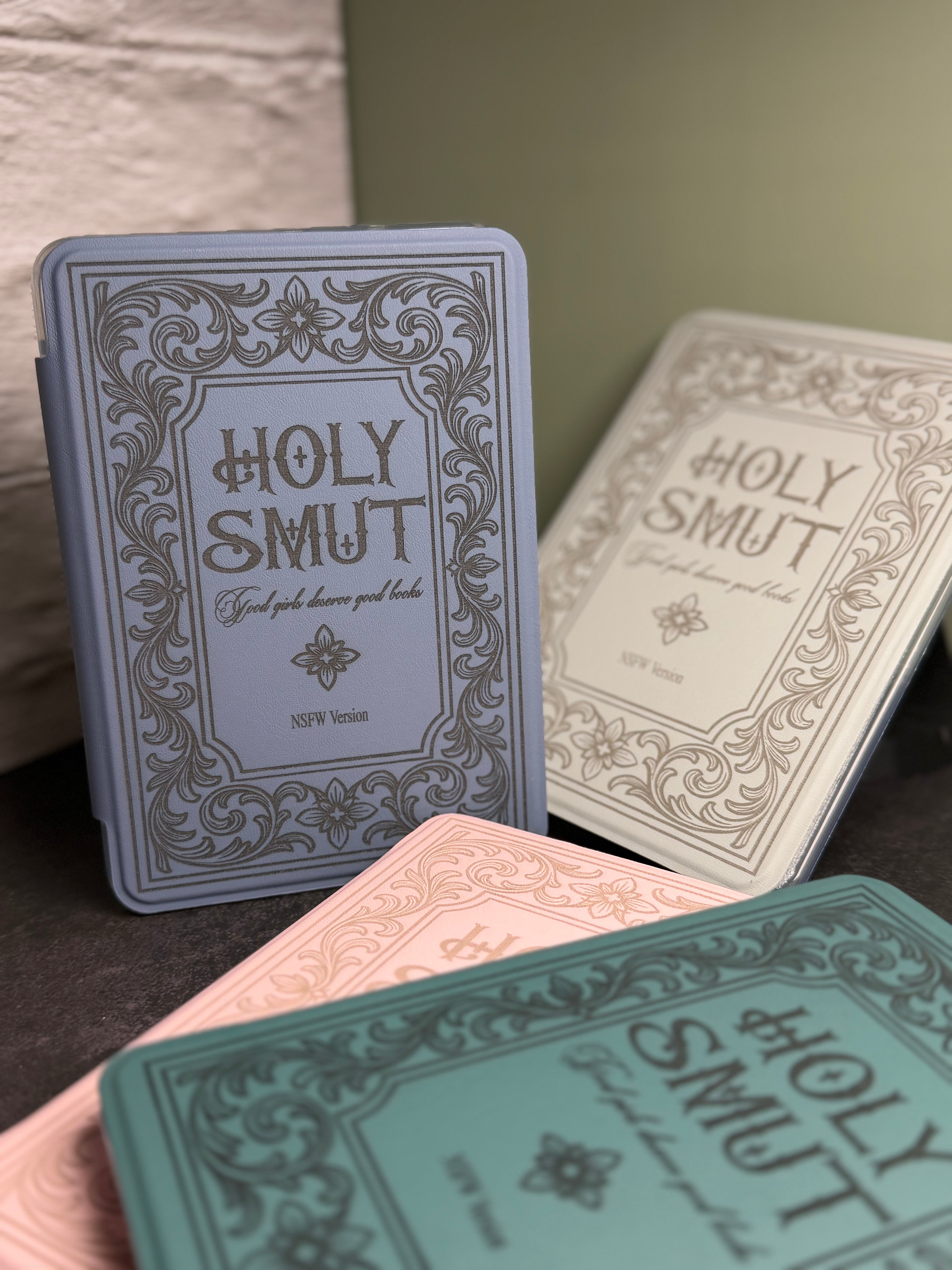 Three 'Holy Smut' books with decorative covers on a surface.