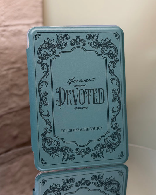 Kindle case with 'Forever Devoted' text and decorative elements on a reflective surface.