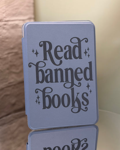 Dusty lavender kindle case with 'Read banned books' text on a reflective surface