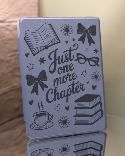 Dark sage Kindle case engraved with saying just one more chapter and a variety of illustrations on a reflective surface