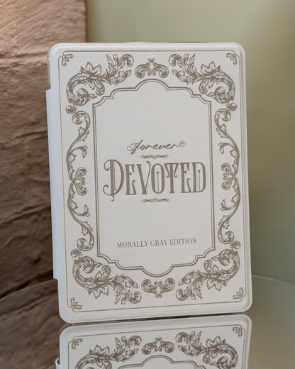 Kindle case with 'Forever Devoted' text and decorative elements on a reflective surface.